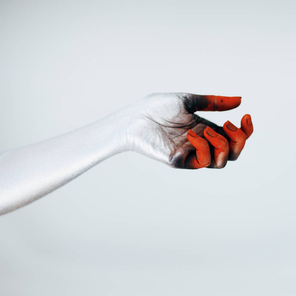 Creepy Halloween monster hand with white, red and black make up in front of white background - Photo, Image