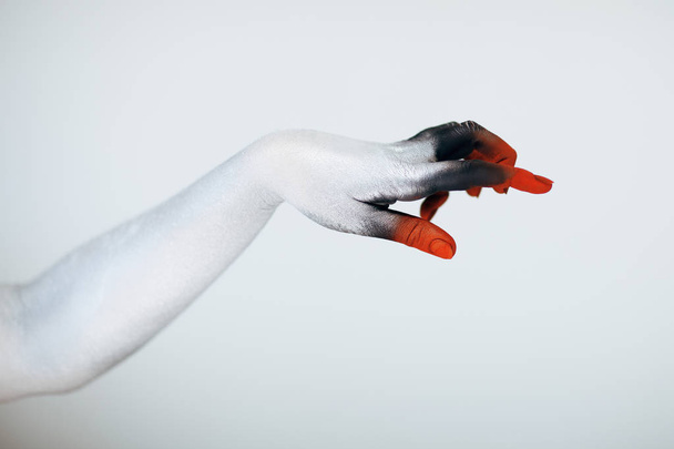 Creepy Halloween monster hand with white, red and black make up in front of white background - Photo, image