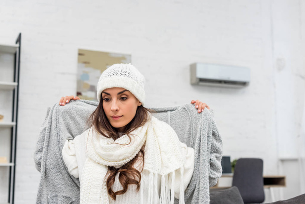freezed young woman putting on warm clothes at home - Photo, Image