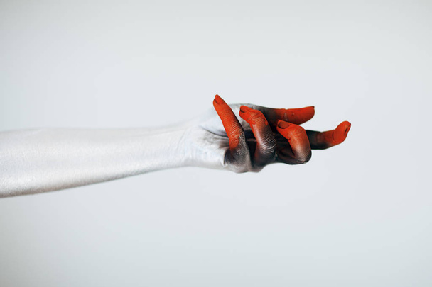 Creepy Halloween monster hand with white, red and black make up in front of white background - Photo, Image