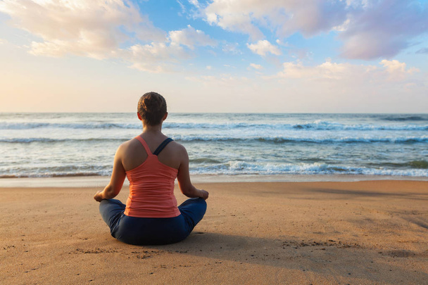 Joven mujer en forma deportiva haciendo yoga al aire libre en la playa
 - Foto, Imagen
