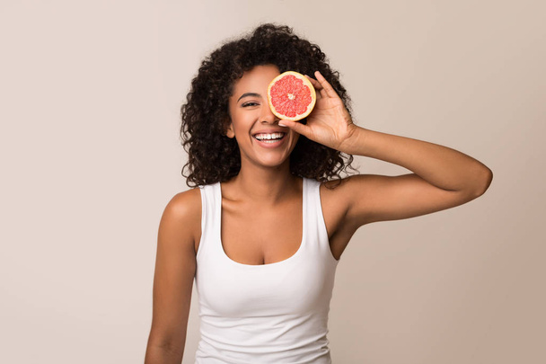 Glückliche junge Frau mit der Hälfte der Grapefruit - Foto, Bild