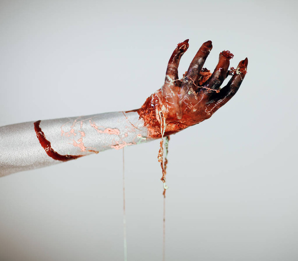 Creepy bloody horror Halloween monster witch hand with white, red and black make up and long creepy fingernails in front of white background - Foto, imagen