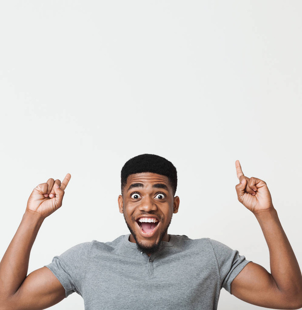 Emocionado hombre afroamericano apuntando hacia arriba en el espacio de copia
 - Foto, Imagen