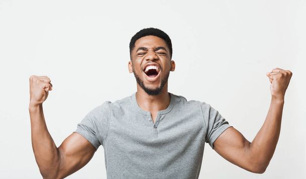 Zwarte man schreeuwen Ja en het verhogen van de gebalde vuisten in de lucht - Foto, afbeelding