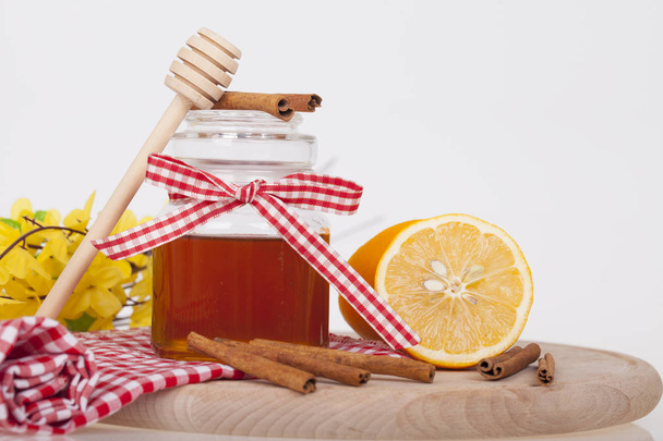 Honey in  jar with honey dipper on a wooden background - Photo, Image