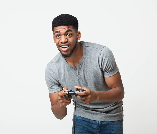 Excited black guy holding joystick and playing video games - Photo, Image