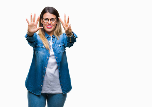 Young beautiful woman over wearing glasses over isolated background showing and pointing up with fingers number eight while smiling confident and happy. - Photo, Image