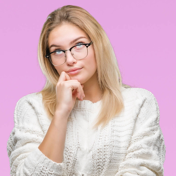Young caucasian woman wearing glasses over isolated background with hand on chin thinking about question, pensive expression. Smiling with thoughtful face. Doubt concept. - Foto, Bild