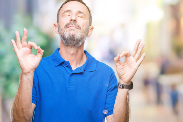 Middle age hoary senior man over isolated background relax and smiling with eyes closed doing meditation gesture with fingers. Yoga concept. - Photo, Image