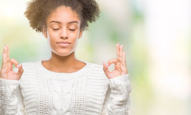 Молодих афро Американку носити взимку светр над ізольованих фон розслабитися та усміхнені очі закриті, робити медитації жест пальцями. Концепція йоги. - Фото, зображення