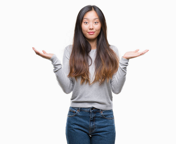Młoda kobieta azjatyckich nad wyrażenie clueless i mylić na białym tle - Zdjęcie, obraz