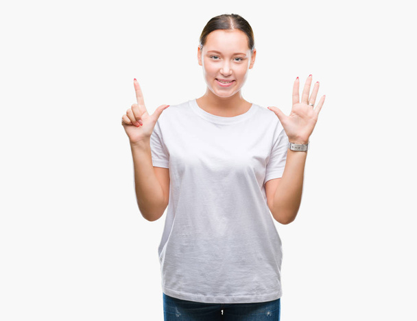 Giovane bella donna caucasica su sfondo isolato mostrando e indicando con le dita numero sette sorridendo fiducioso e felice
. - Foto, immagini