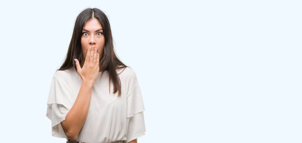 Young beautiful hispanic woman cover mouth with hand shocked with shame for mistake, expression of fear, scared in silence, secret concept - Photo, Image