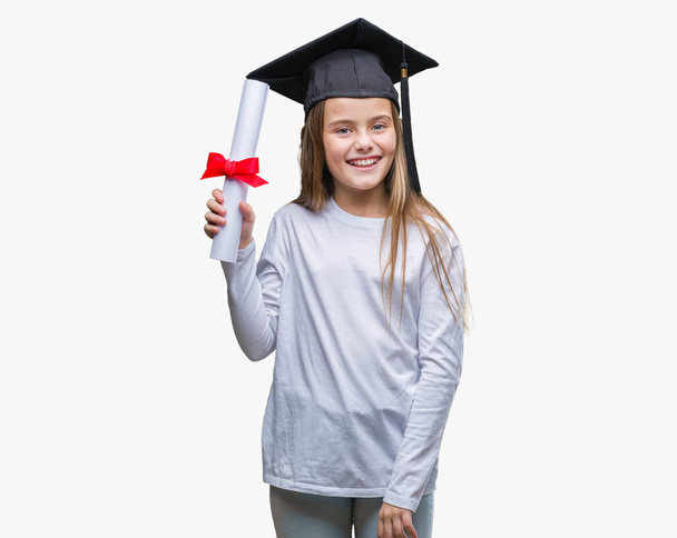 Молодая красивая девушка в дипломной шапке держа степень на изолированном фоне с счастливым лицом стоя и улыбаясь с уверенной улыбкой показывая зубы
 - Фото, изображение