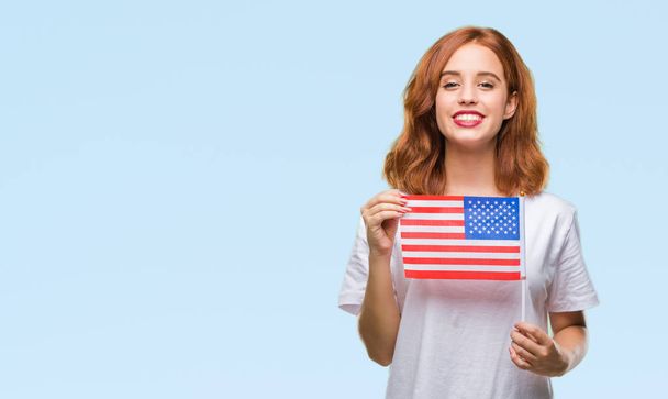 Mladá krásná žena drží vlajky amerických izolované pozadí s šťastný obličej stál a usmíval se s důvěřivým úsměvem ukázal zuby - Fotografie, Obrázek