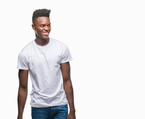 Fiatal afroamerikai férfi át elszigetelt háttér keres el az oldalon mosollyal arcán, természetes kifejezése. Nevetve magabiztos. - Fotó, kép