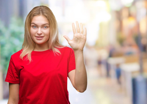 junge kaukasische Frau über isoliertem Hintergrund, die mit Finger Nummer fünf zeigt und nach oben zeigt, während sie selbstbewusst und glücklich lächelt. - Foto, Bild