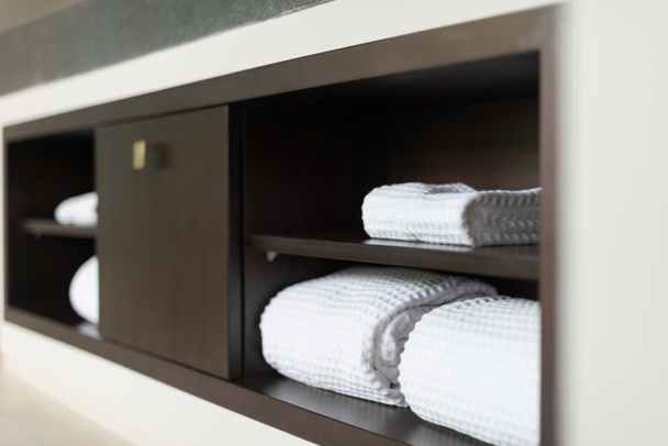 Asciugamani bianchi laminati sullo scaffale nel bagno dell'hotel
. - Foto, immagini