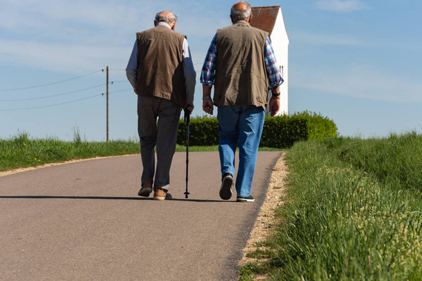 Due uomini anziani che passeggiano vicino al paese
. - Foto, immagini