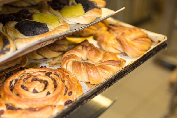 ψησίματος αρτοσκευάσματα και ψωμί στο φούρνο με χρυσό καφέ νόστιμα χρώματα σε ένα αρτοποιείο στη νότια Γερμανία - Φωτογραφία, εικόνα