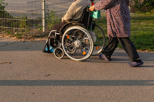 Wieczorem starszy para z wózków inwalidzkich w odkryty park w south Niemcy wiosenny historyczne miasta Słoneczny - Zdjęcie, obraz