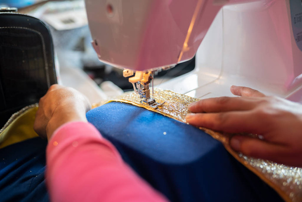 Θηλυκό ράψιμο μια Απόκριες φορεσιά παιδί στο μηχάνημα. - Φωτογραφία, εικόνα