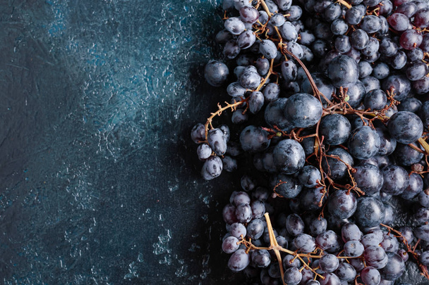 Vista superior de uvas de color azul oscuro sobre un fondo vintage, copia el espacio para tu texto
. - Foto, imagen