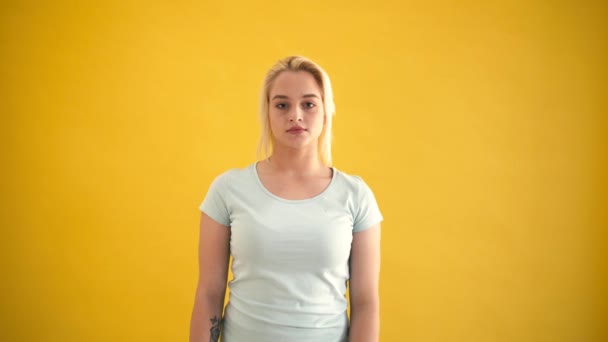 Legrační blond kavkazské plus size model ukazuje mírové gesto na žlutém podkladu - Záběry, video