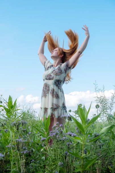 Beautiful young vital sexy woman enjoying in nature in the fresh air. Joy. Freedom. Happiness. Lust raises her arms - Photo, Image