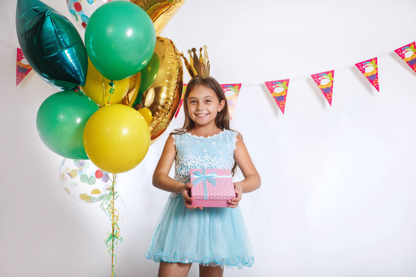 Cute little girl in birthday cap holding present. Holidays concept. - Foto, Imagem