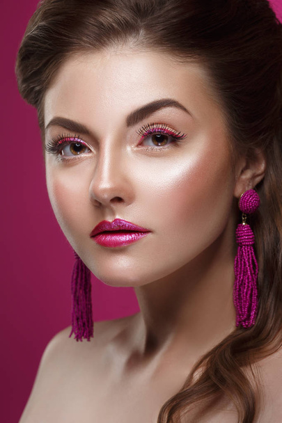 Fashion beauty portrait of a beautiful girl with a bright make-up and an elegant hairdress on a pink background. - Valokuva, kuva