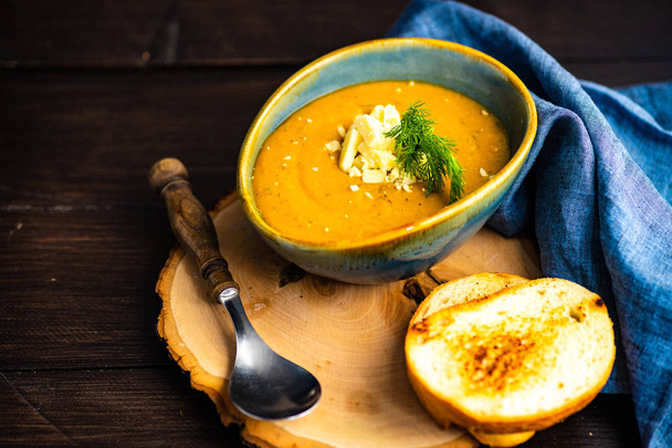 Autumnal food concept with bowl of tasty cream soup on rustic background with copy space - Photo, Image