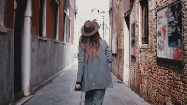 Camera suit attrayant journaliste professionnel avec caméra marchant le long de la belle rue à Venise, Italie
. - Séquence, vidéo