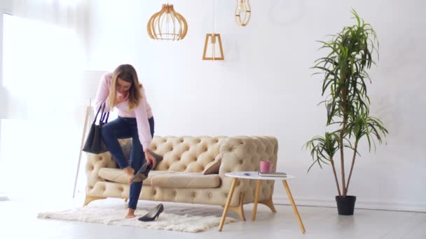 Kobieta przy wysoki obcas buty po pracy w domu - Materiał filmowy, wideo
