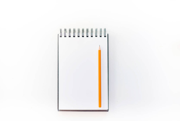 Cuaderno de bocetos blanco con lápiz naranja y despertador azul. Concepto de educación y planificación, fondo abstracto blanco. Mock-up Concept. Fondo blanco, aislado, de cerca
  - Foto, imagen