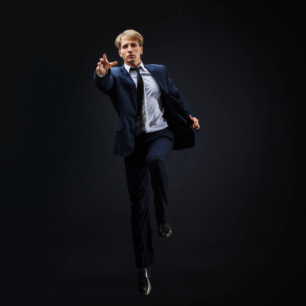 Businessman jumping up. Young man in business suit seeking higher - 写真・画像