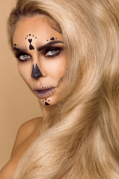 Piękna Blondynka w Halloween makijaż i piękne włosy na beżowym tle w studio. Szkielet, monster i czarownica. - Zdjęcie, obraz