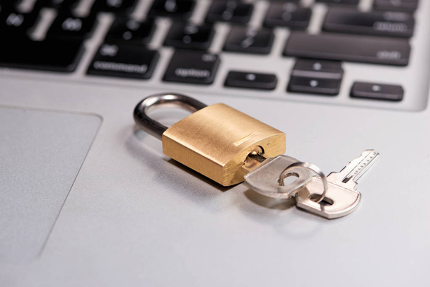 close-up of locked lock and key on keyboard of laptop - Photo, image
