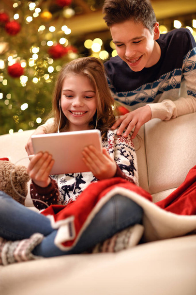 Cute girl listening music and enjoy with brother for Christmas eve - Foto, imagen