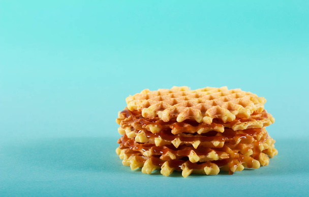 Stack of caramel crisp waffles over blue background - Foto, Imagem