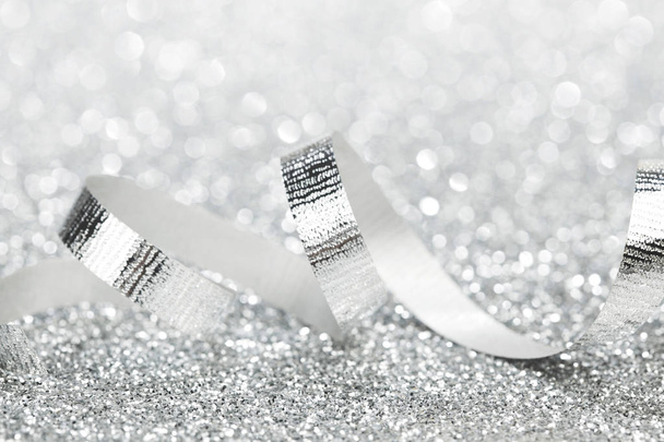 Shiny silver gift ribbon on bokeh background close-up - Фото, изображение