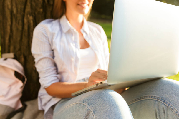 Close up of a young girl spending time at the park, studying, sitting with laptop computer - Photo, Image