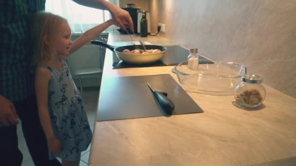 Vater im karierten Hemd kocht für seine Kinder Hühnchen-Drumsticks für gesundes Abendessen in der heimischen Küche - Filmmaterial, Video