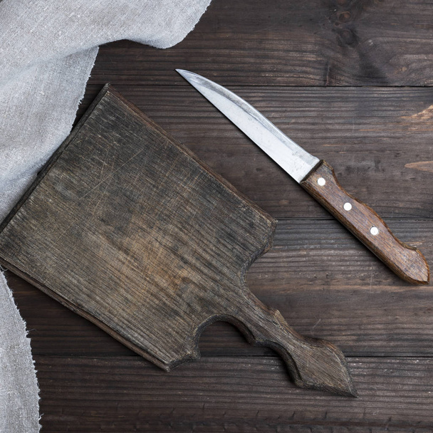 empty old brown wooden cutting board and knife on the table, top view - 写真・画像