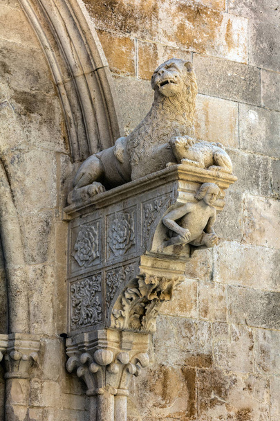 Портал собора Святого Марка в Корчуле, Хорватия, построенный Бонино да Милано в 1412 году, содержит типичные романские мотивы, такие как лев, рвущий свою добычу и приседающая фигура Адама
 - Фото, изображение