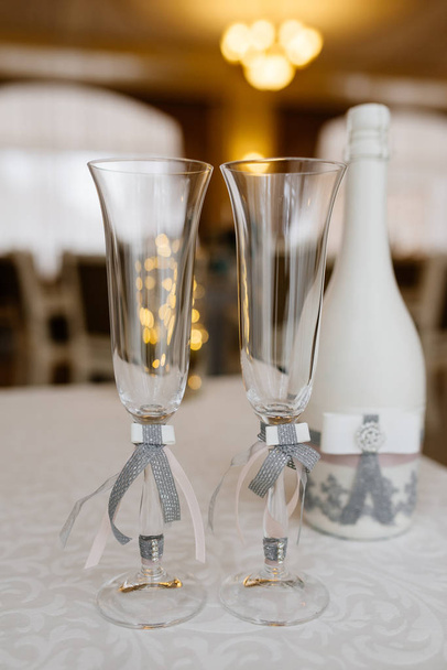 Γυαλιά του γαμπρού και της νύφης σε ένα γάμο τραπέζι. Κομψή γάμος λεπτομέρειες - Φωτογραφία, εικόνα