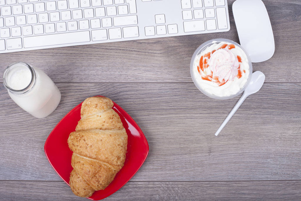 Tastatur, Frühstück und Dessert im Glas auf einem Holztisch von oben - Foto, Bild
