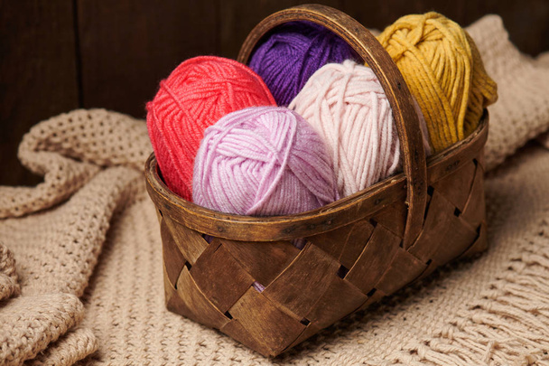 colorful wool threads for knitting in basket, wooden background - Photo, Image