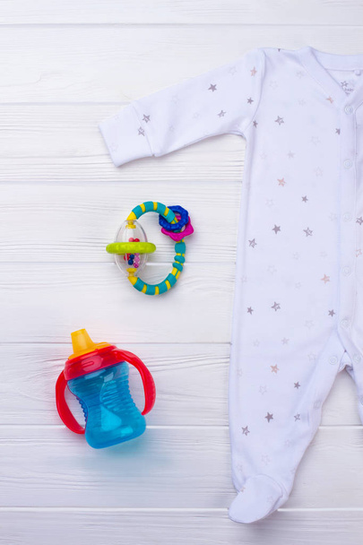 Baby footed sleepwear pajama and toys. Blue bottle and rattle for newborn baby. - Photo, Image